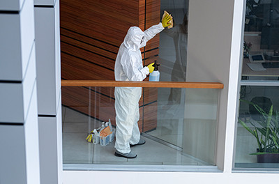 Mitarbeiter in Spezialanzug reinigt ein Fenster in Dortmund